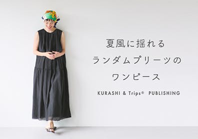 夏風に揺れるランダムプリーツのノースリーブワンピースの画像
